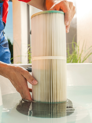 Pool technician removing and cleaning a pool filter cartridge